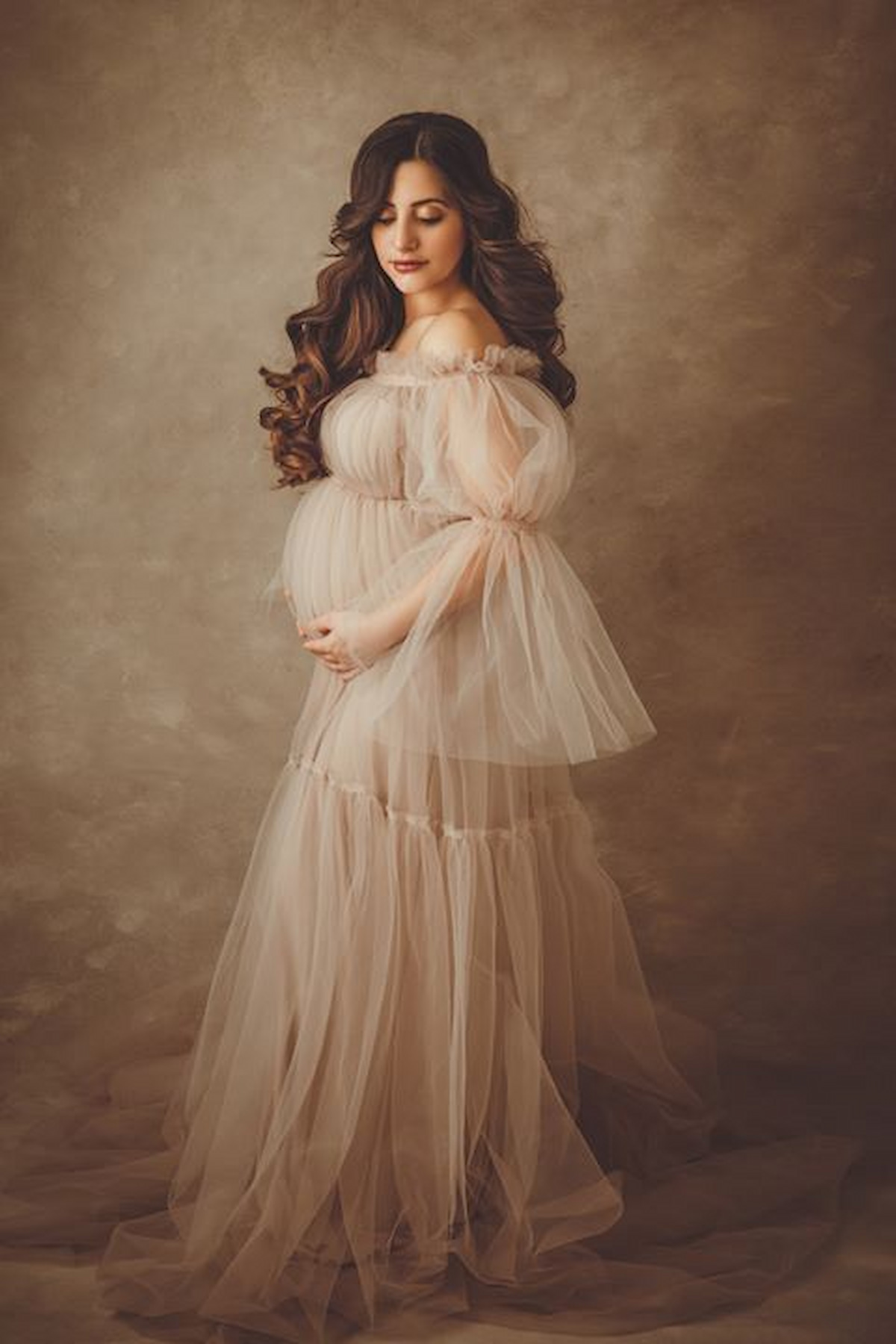 pregnant woman in off shoulder tulle maternity dress