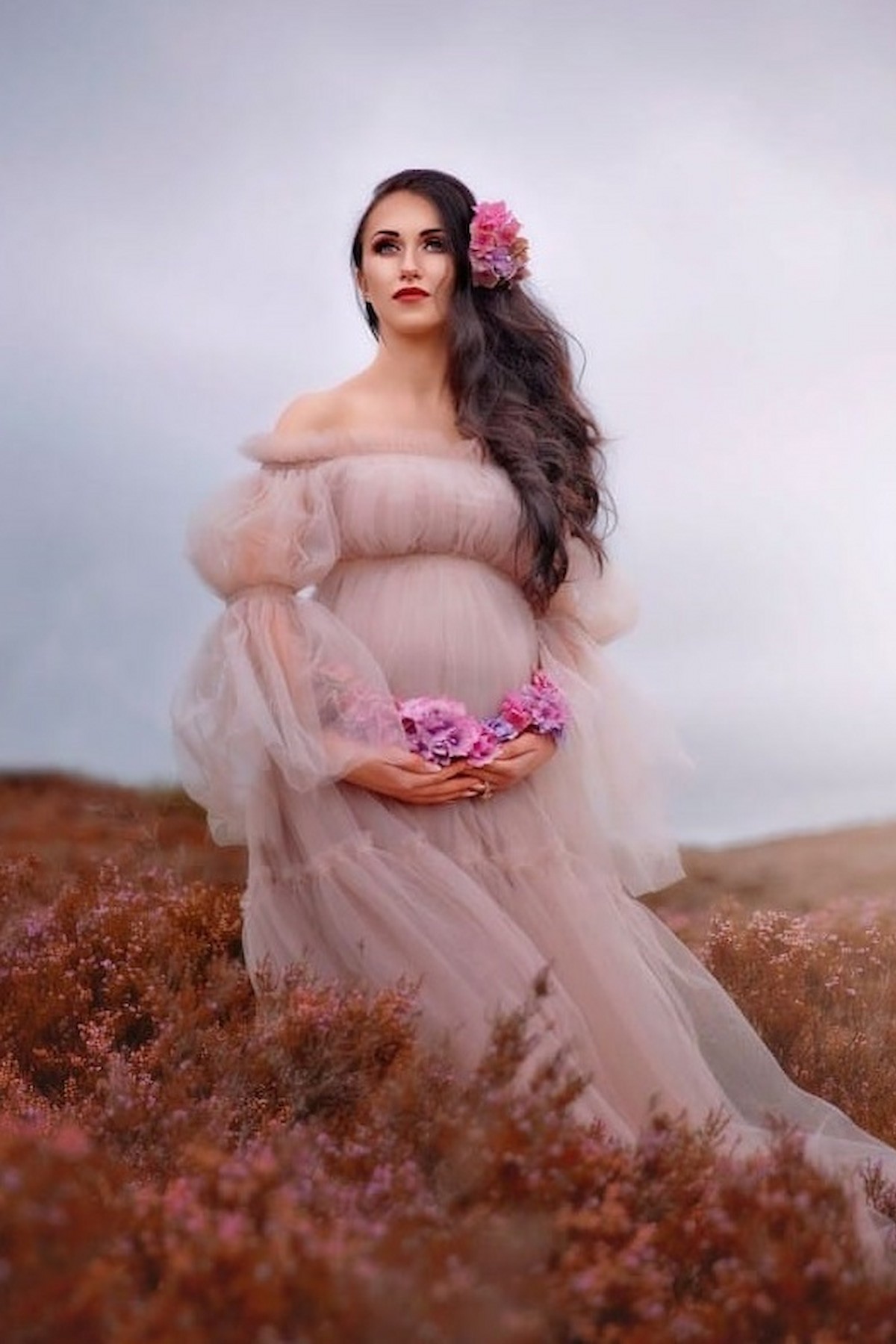 pregnant woman lying in soft tulle maternity gown fine art photography