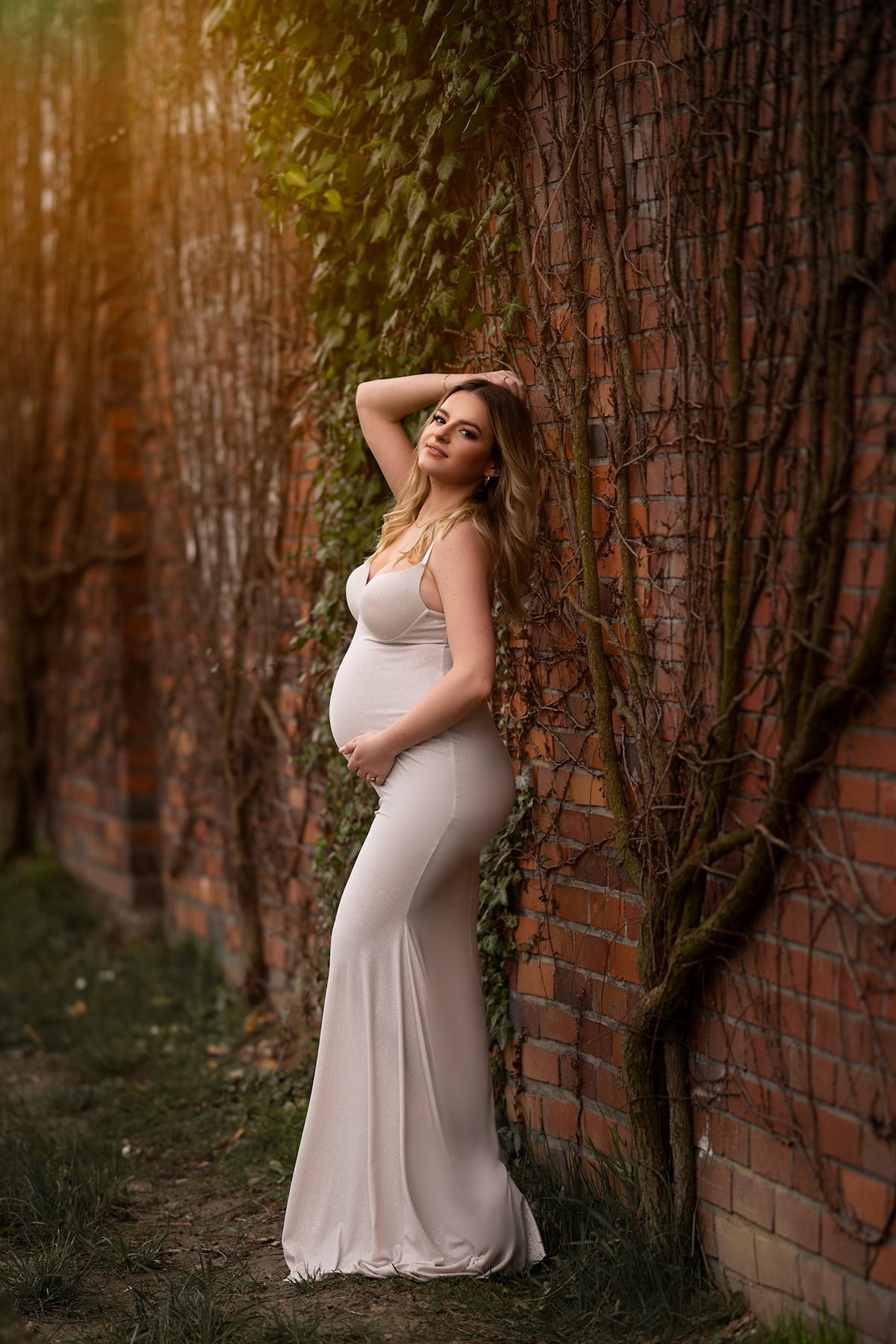 elegant minimalist pregnancy gown outdoor photoshoot by brick wall
