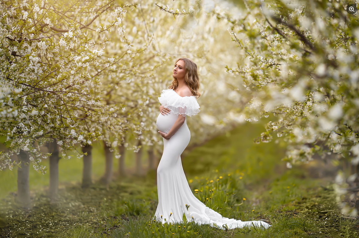 Maternity photoshoot dress in orchard with long fitted silhouette and delicate ruffle