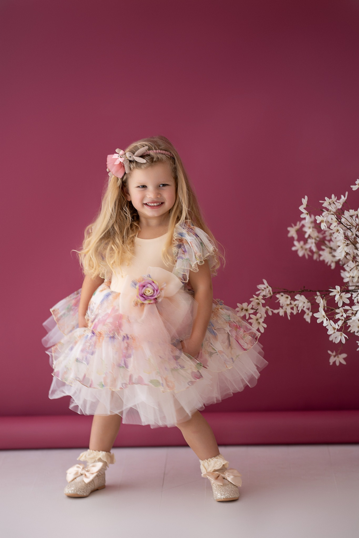 Little girl posing in a fluffy tulle dress with sheer ruffled sleeves