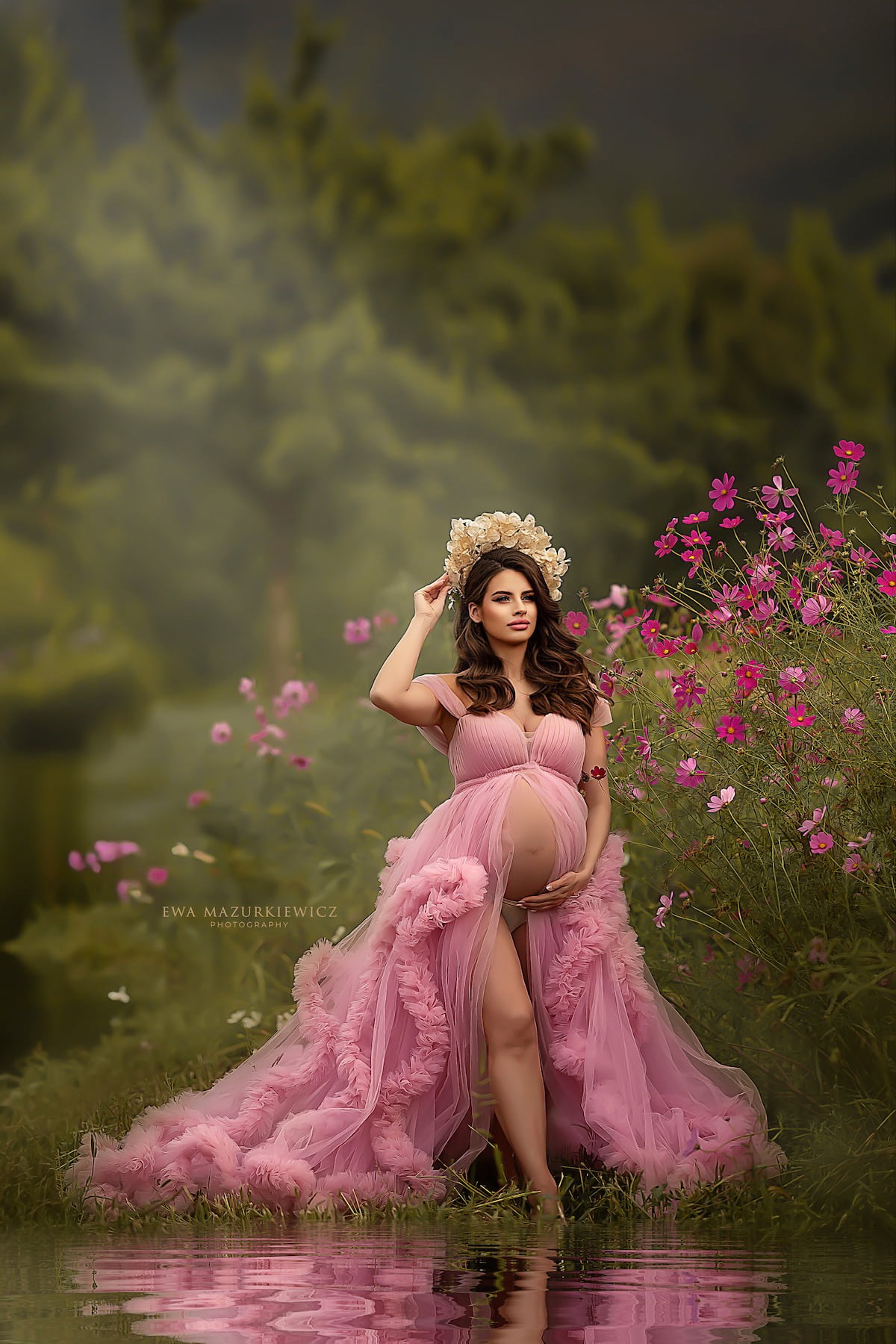 maternity photoshoot in flower field wearing pink ruffle pregnancy dress
