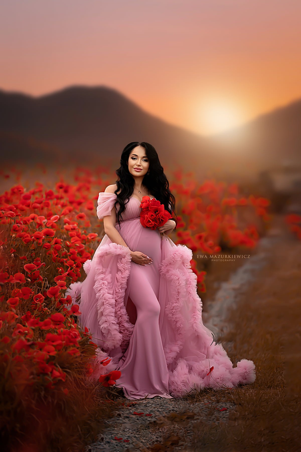 maternity photoshoot in flower field wearing pink ruffle pregnancy dress