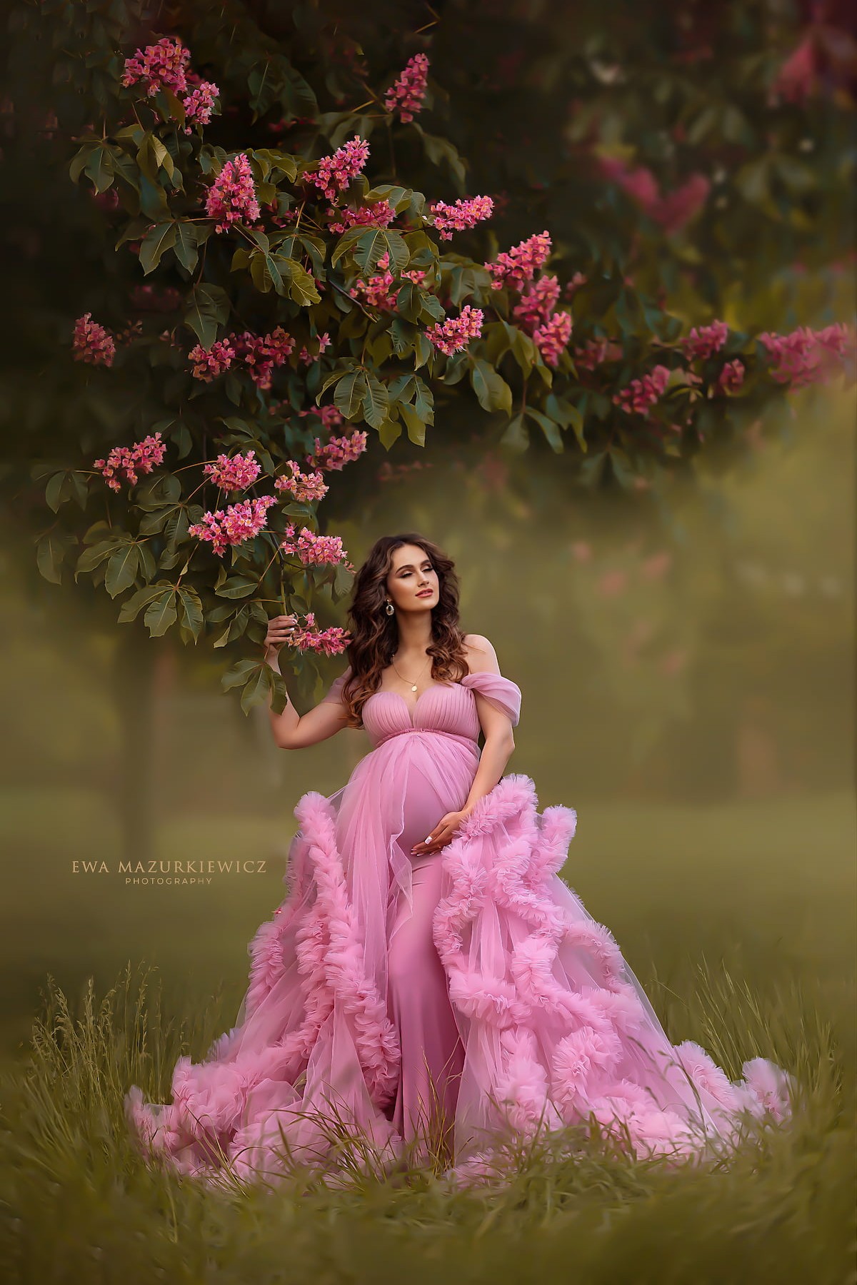maternity photoshoot in flower field wearing pink ruffle pregnancy dress