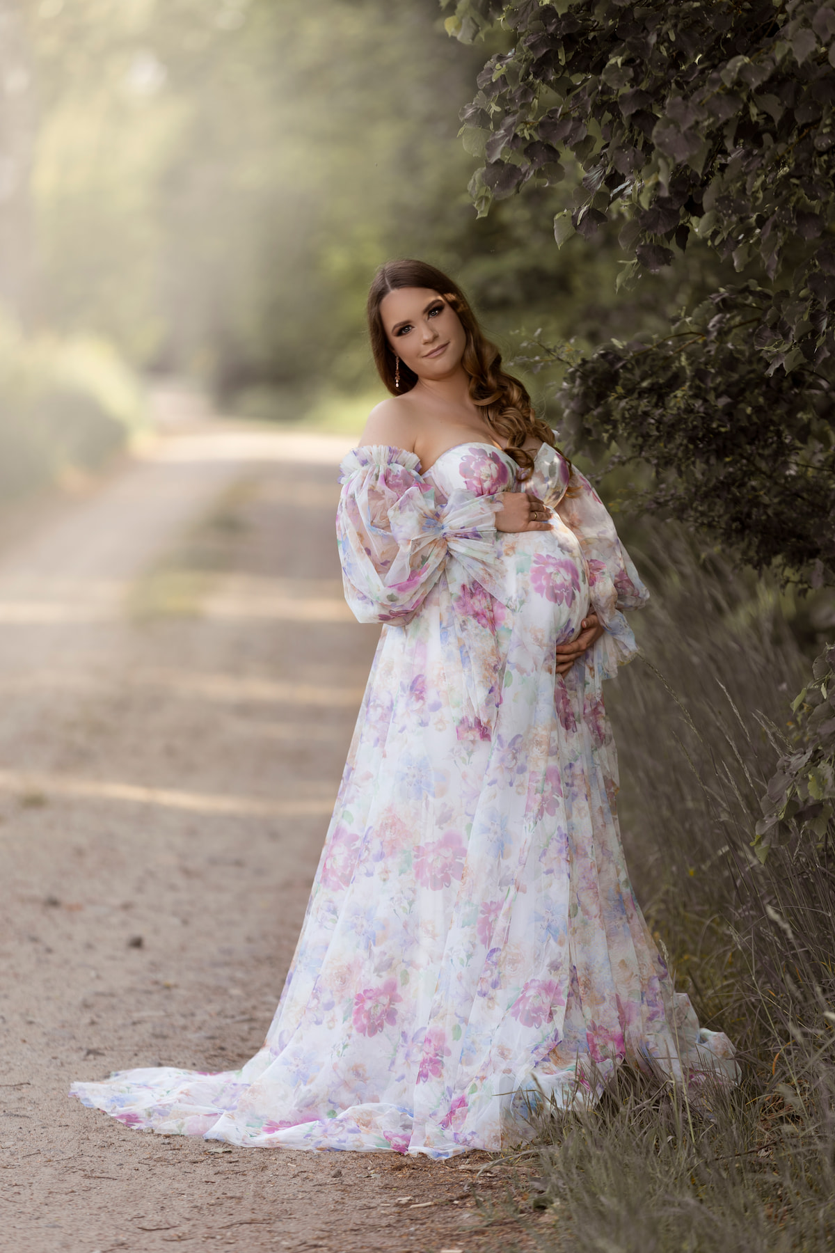 Elegant maternity photoshoot with Rosa dress featuring delicate floral print and sheer tulle sleeves.
