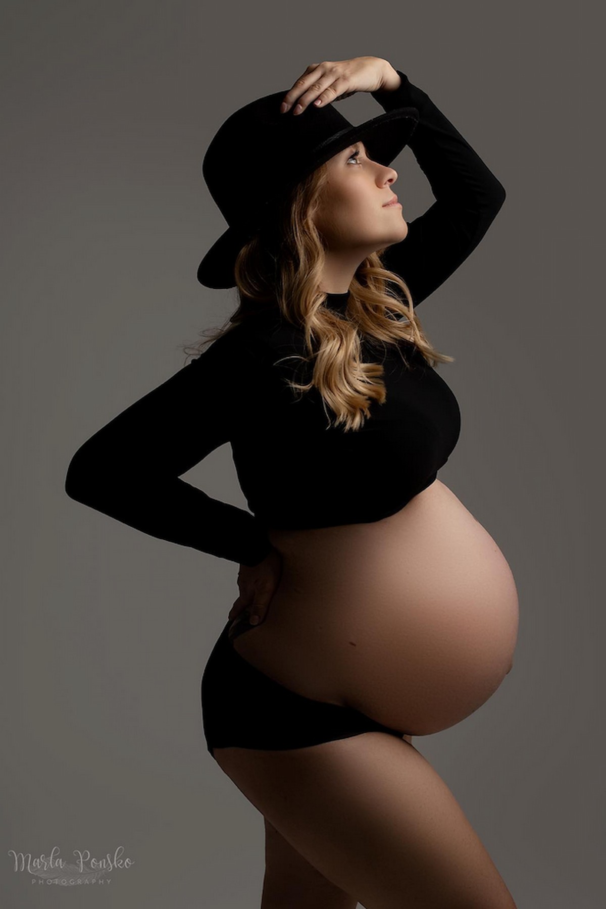 pregnancy photoshoot styling black outfit with hat maternity studio session