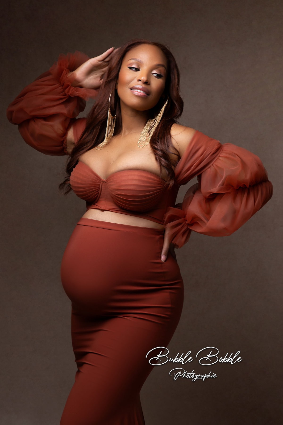 rust maternity gown with puff sleeves and train
